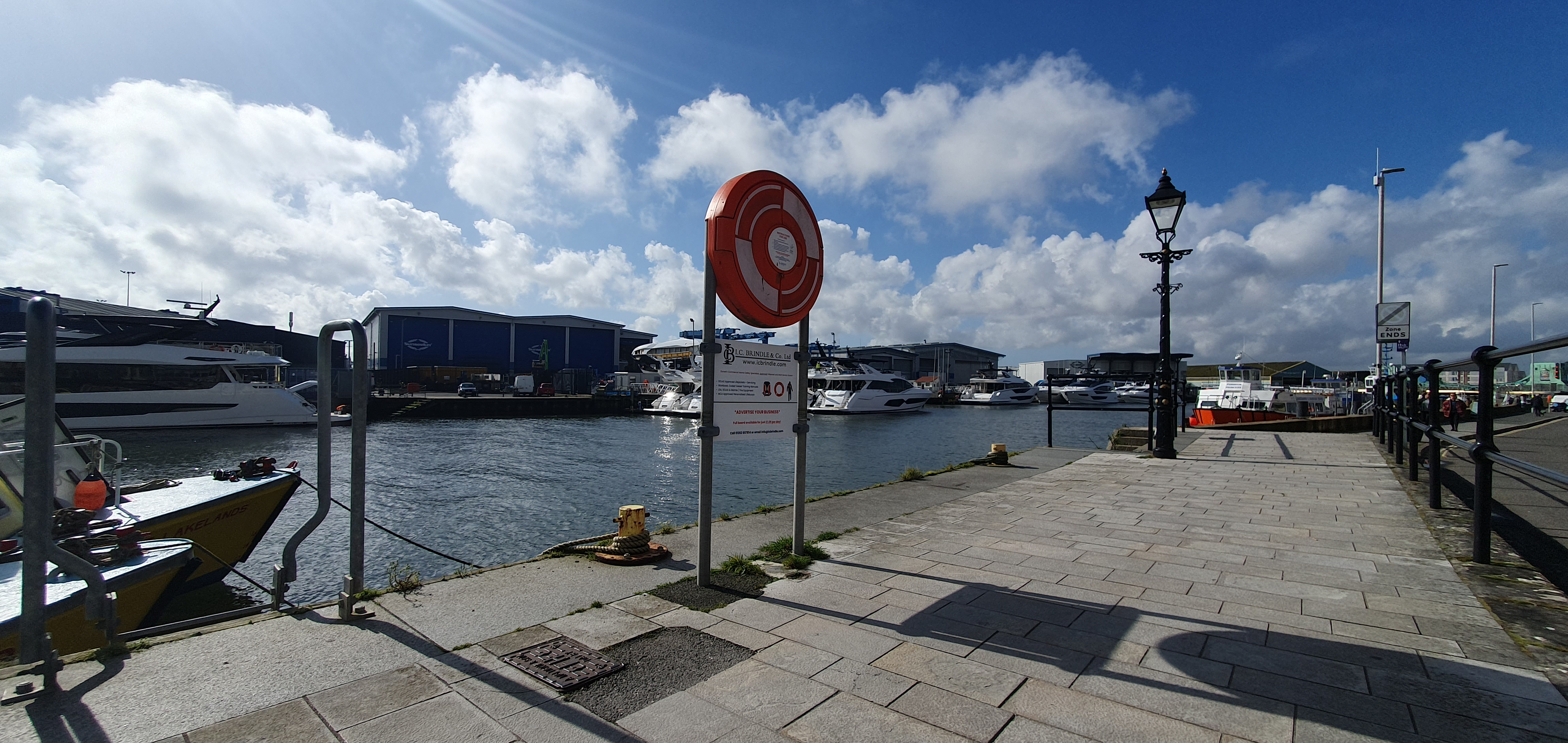 Hard Surface Lifebuoy Housing with Ad Space Signage, situated on Poole Quay, providing safety equipment and advertising opportunities in a waterfront setting