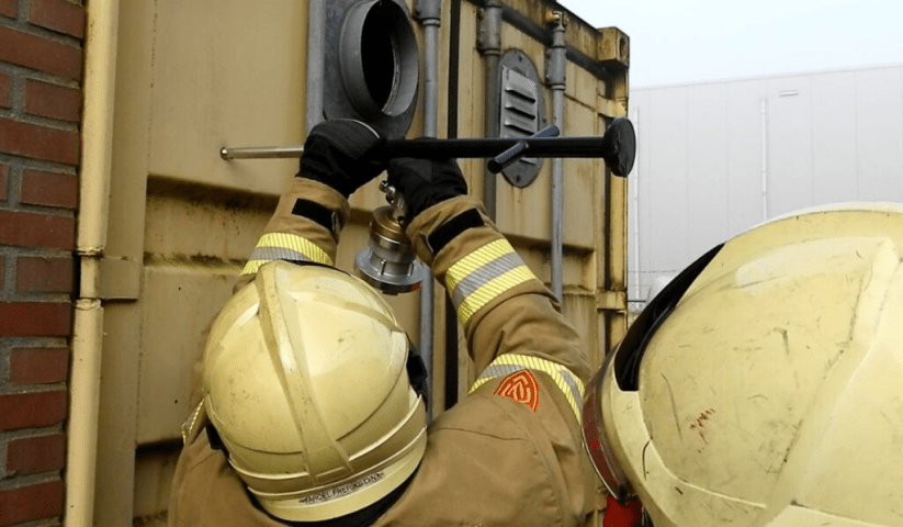 The water mist lance in action - being utilised by a team of fire fighters, which will then penetrate the storage container with its powerful spray.