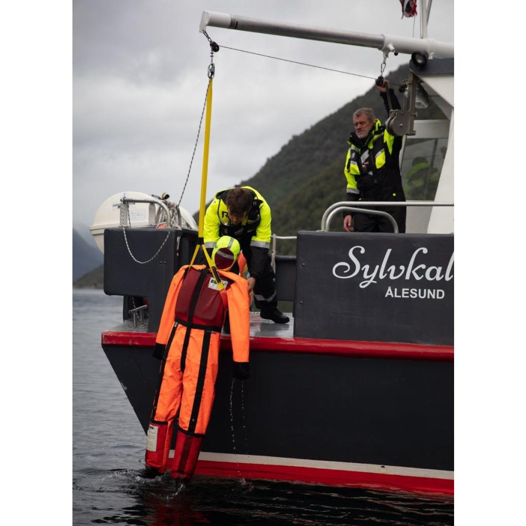 Two individuals collaborating to utilise the SB Rescue Davit and SB Rescue Sling, bringing a MOB Training Dummy on board the vessel.