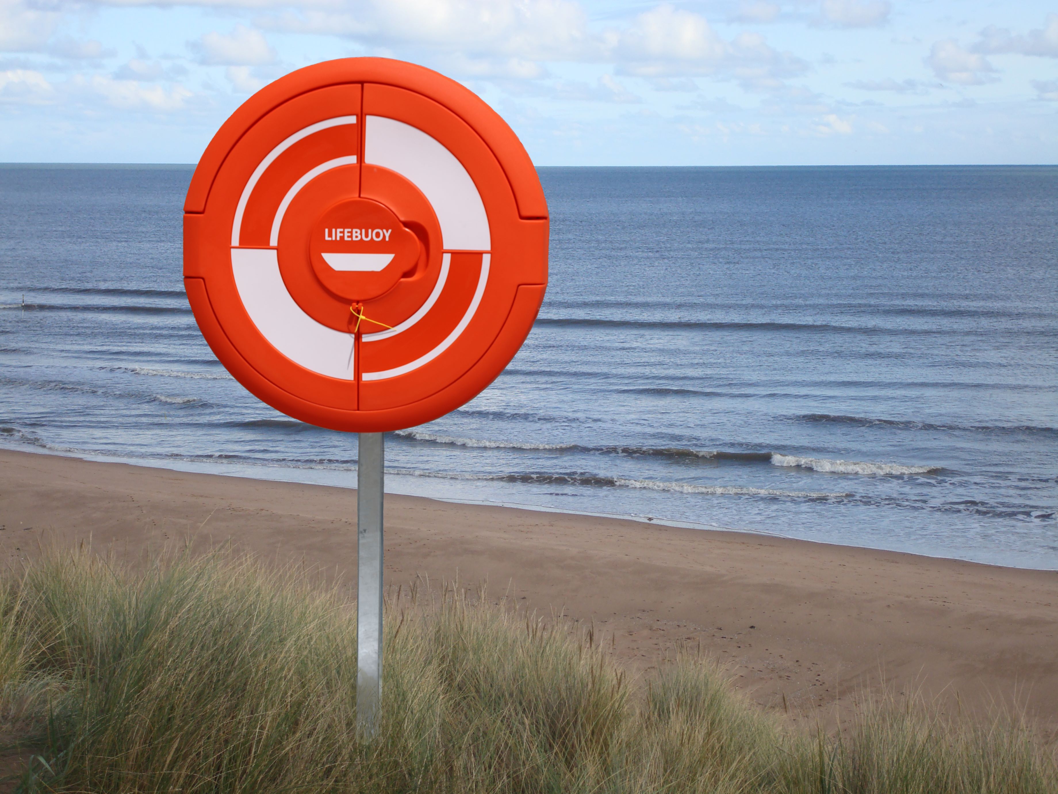 Soft-Surface Lifebuoy Housing/Cabinet mounted above a beach, providing accessible safety equipment in a coastal setting.